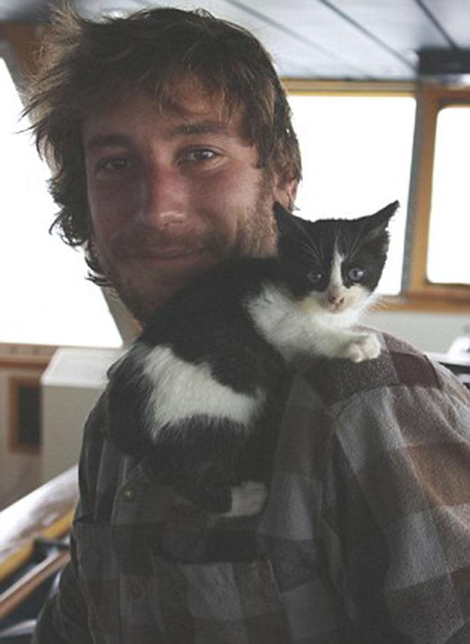 Safe and sound - Manu Wattecamps is pictured with his cat 'Pipalup'. He tucked the kitten in his sweater as he made a daring leap to safety during a storm off Alaska © Julian Robinson